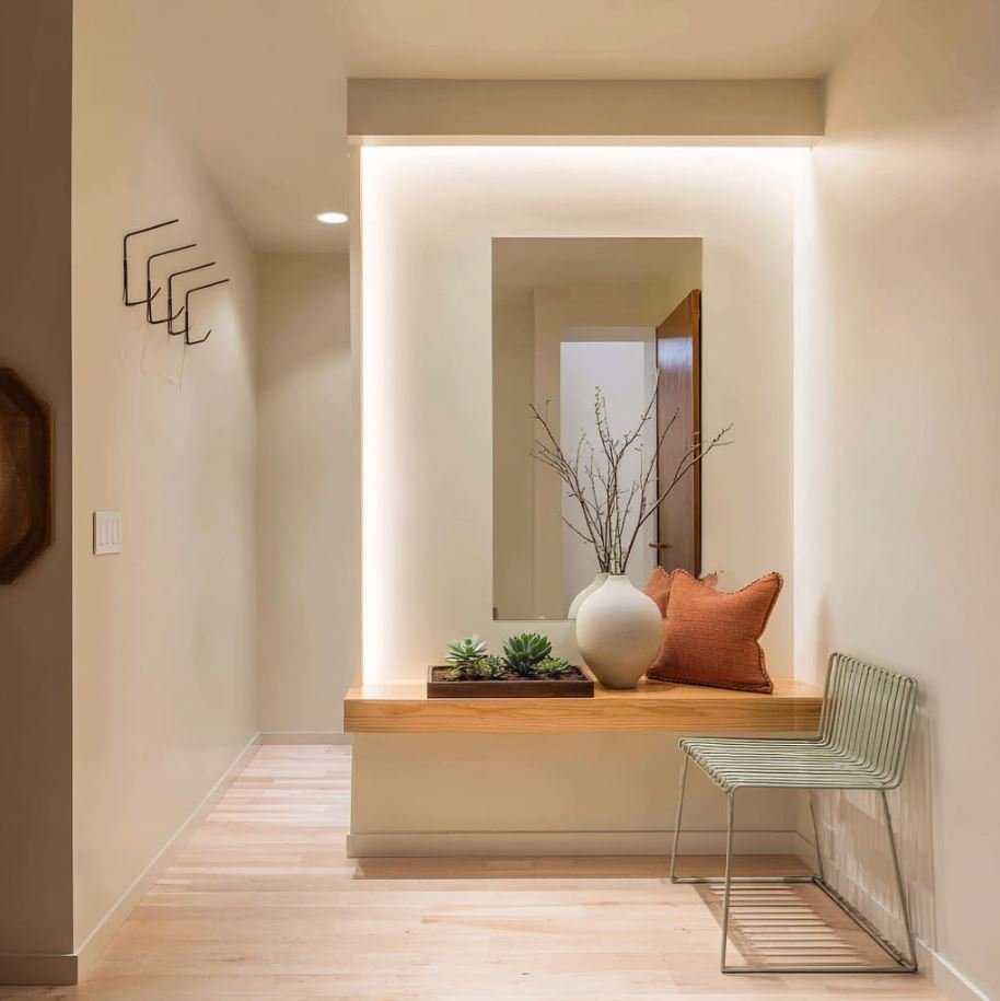 Small entrance lobby with decorative mirror and warm lighting