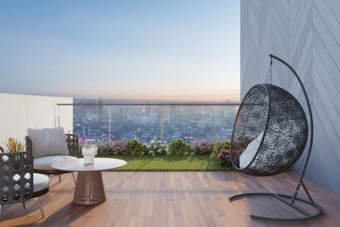 Modern high-rise apartment balcony garden with potted plants hanging chair and sweeping city skyline view