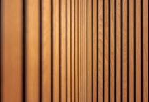 Acoustic Wall Paneling and Noise Reduction Solutions for Remote Workspaces Modern acoustic wood slat wall paneling installed in a home office workspace for sound absorption