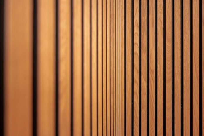 Modern acoustic wood slat wall paneling installed in a home office workspace for sound absorption