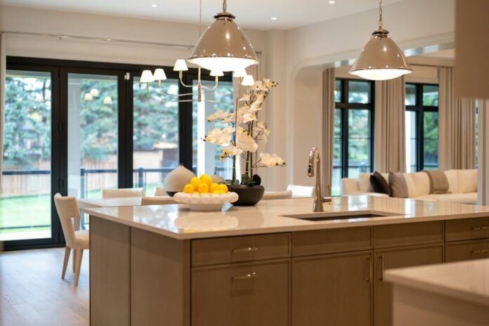 Open plan living and dining space with elegant pendant lights layered ceiling illumination and warm ambient lighting