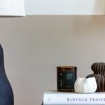 Artisanal ceramic vase and textured tabletop styling vignette on an elegant coffee table with books and warm ambient decor
