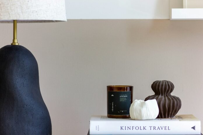 Artisanal ceramic vase and textured tabletop styling vignette on an elegant coffee table with books and warm ambient decor