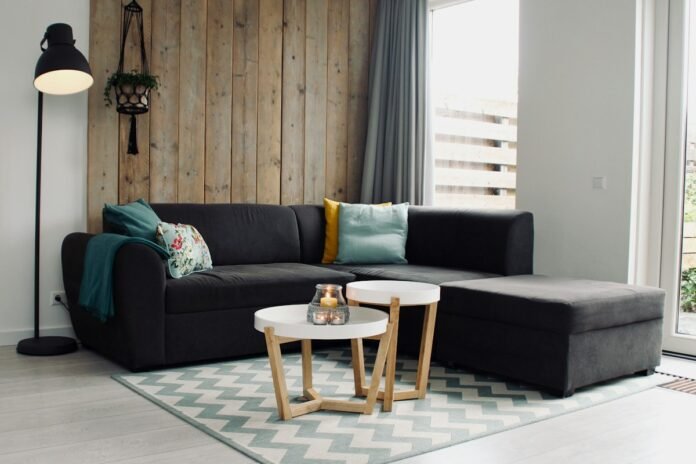 Handwoven wool area rug anchoring a modern living room seating arrangement with sectional sofa coffee table and warm hardwood flooring