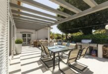 Weatherproof Covered Pergola Patio Designs for Year-Round Outdoor Entertainment Modern weatherproof covered pergola patio with comfortable outdoor seating dining area and architectural shelter