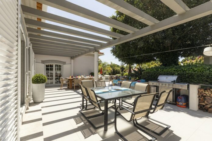Weatherproof Covered Pergola Patio Designs for Year-Round Outdoor Entertainment Modern weatherproof covered pergola patio with comfortable outdoor seating dining area and architectural shelter