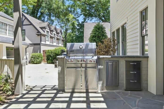 Built-in outdoor kitchen BBQ island with stainless steel cabinets natural granite countertops and professional gas grill