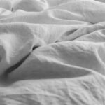 Organic linen bedding styling essentials layered in a serene modern master bedroom