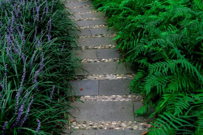 Natural flagstone walkway set in pea gravel garden pathway surrounded by lush residential plantings